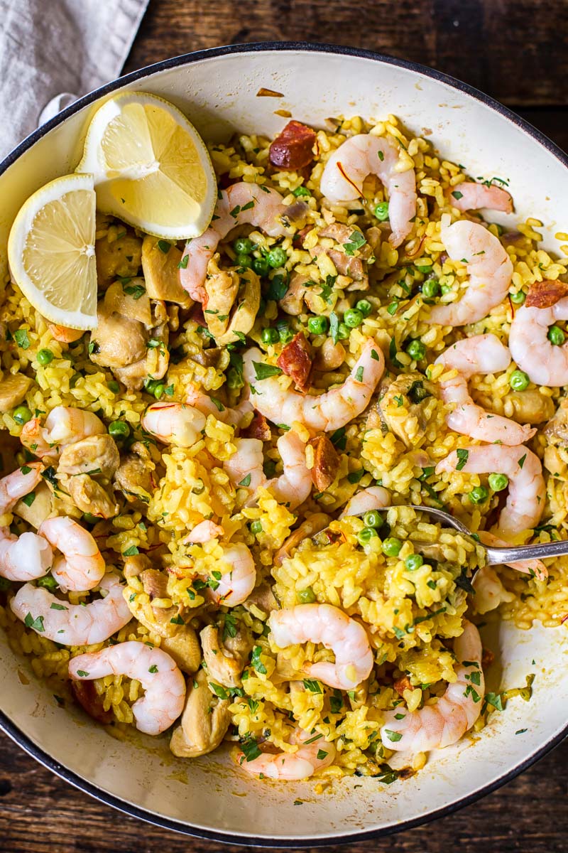top down view of yellow Spanish rice with chicken, shrimp and lemon slices