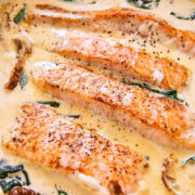 salmon in cream sauce with sun-dried tomatoes and spinach