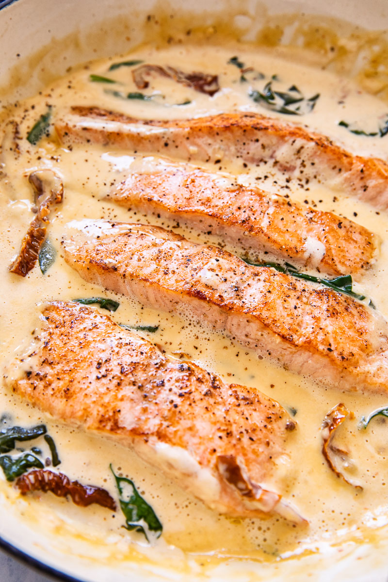 salmon in cream sauce with sun-dried tomatoes and spinach