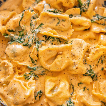 tortellini in creamy sauce in cast iron pan