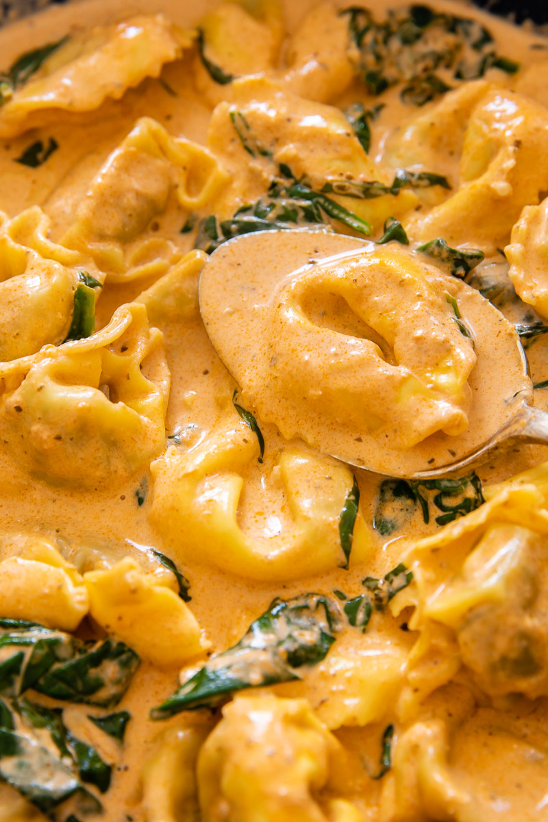close up of tortelloni in a sauce with spinach
