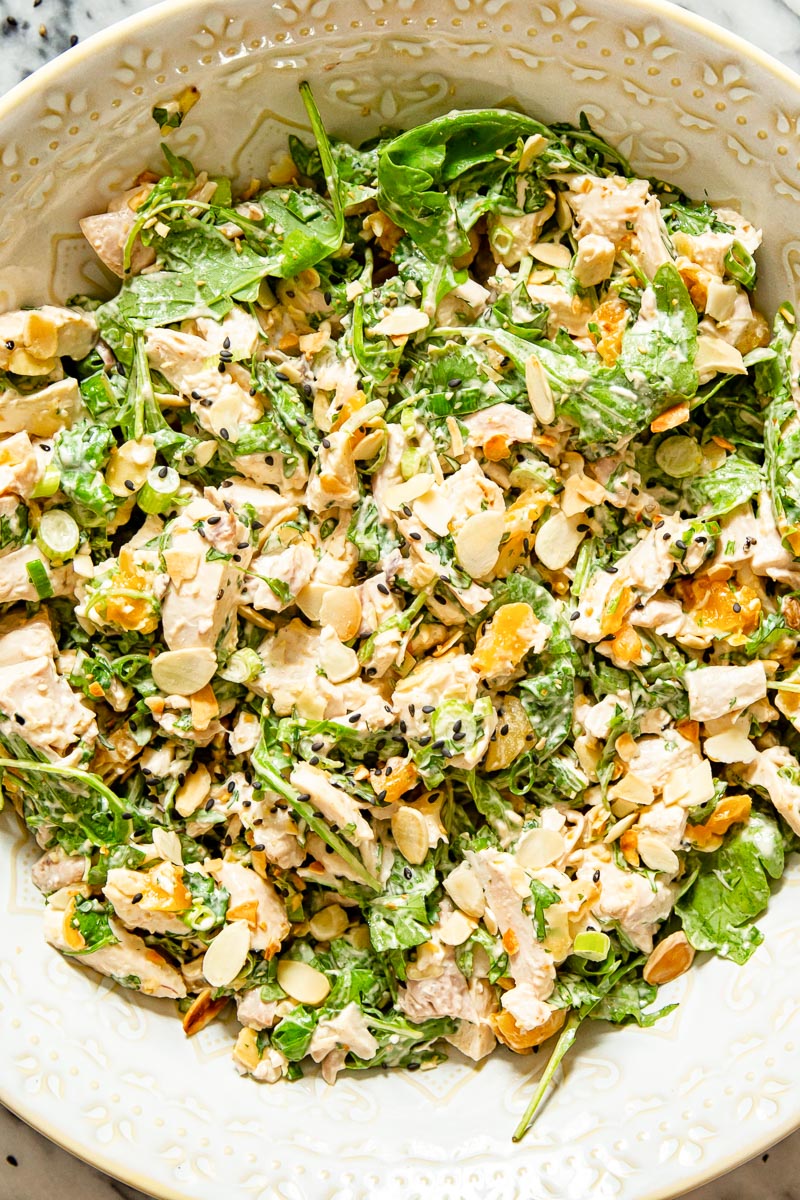 chicken salad with arugula, almonds and apricots in a bowl