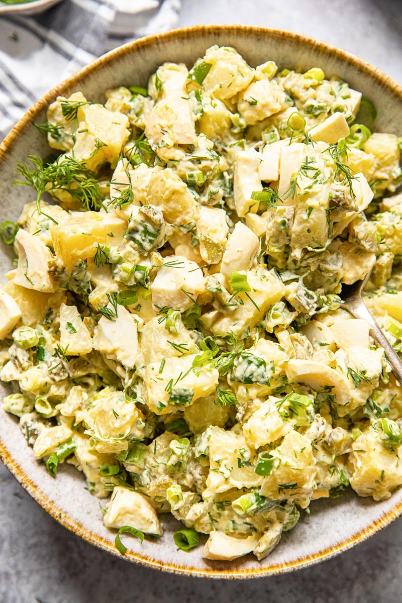 top down view of potato salad with dill and green onions