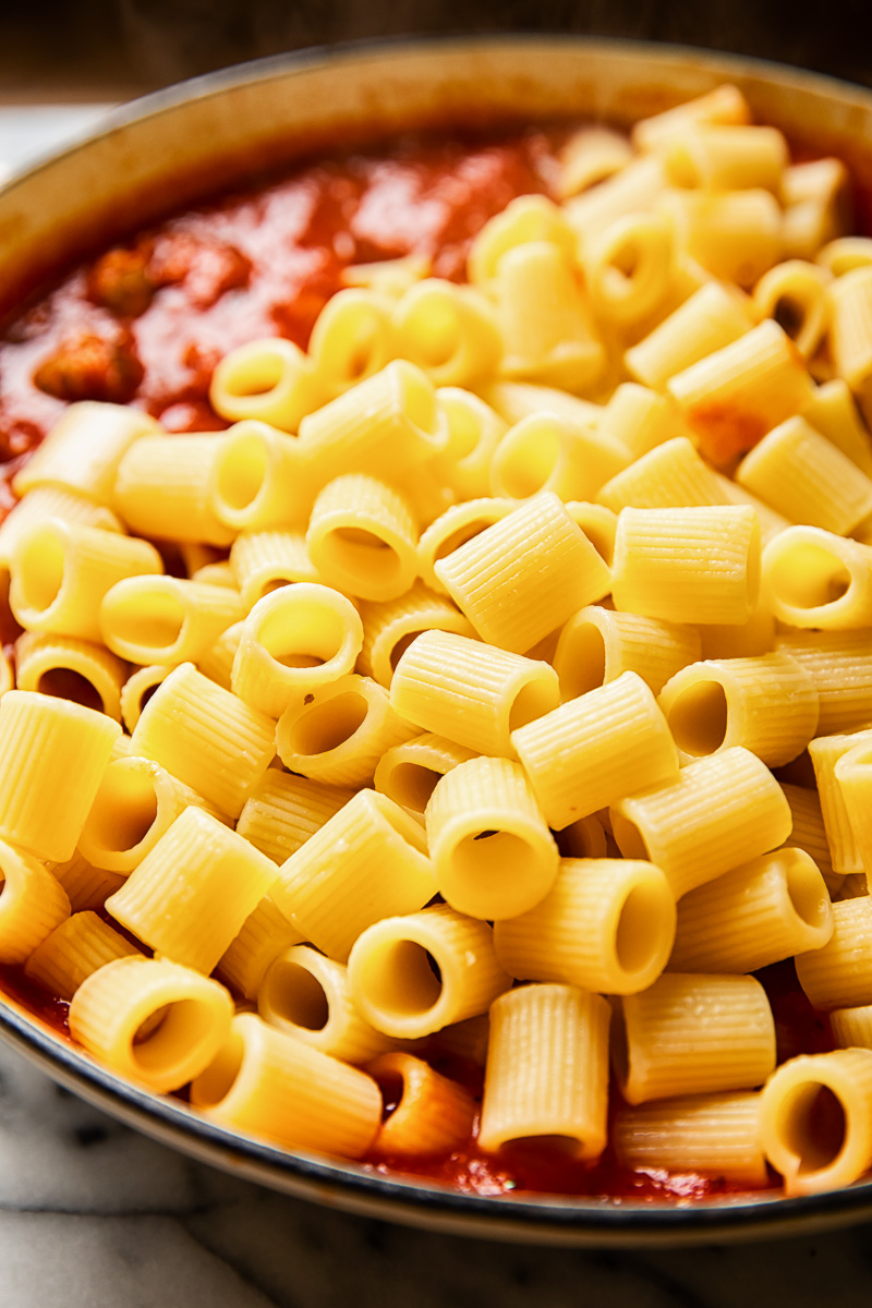 rigatoni on top of pasta sauce in a pan