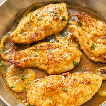 top down view of chicken breasts in lemon sauce in a pan