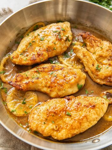 top down view of chicken breasts in lemon sauce in a pan