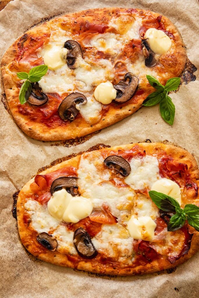 Two pizzas on a baking sheet