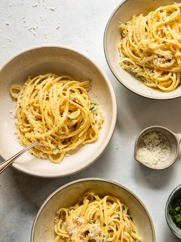 top down view of linguine in three cream coloured bowls