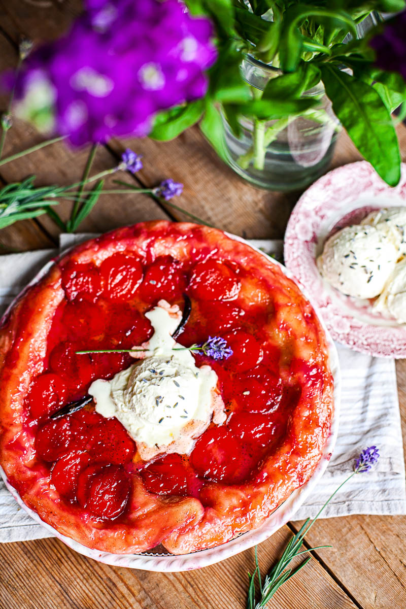 tarte tatin on wooden table, purple flower in vase