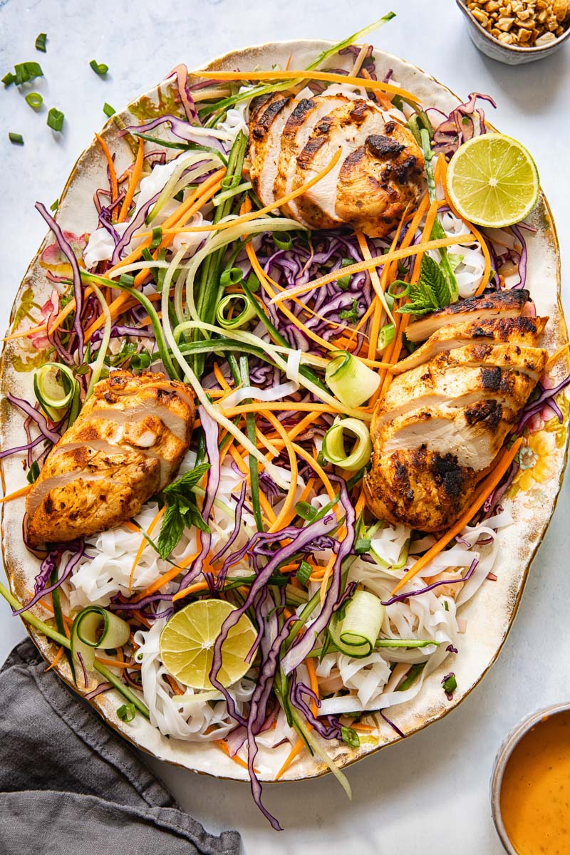 top down view of grilled chicken and salad in a large oval platter