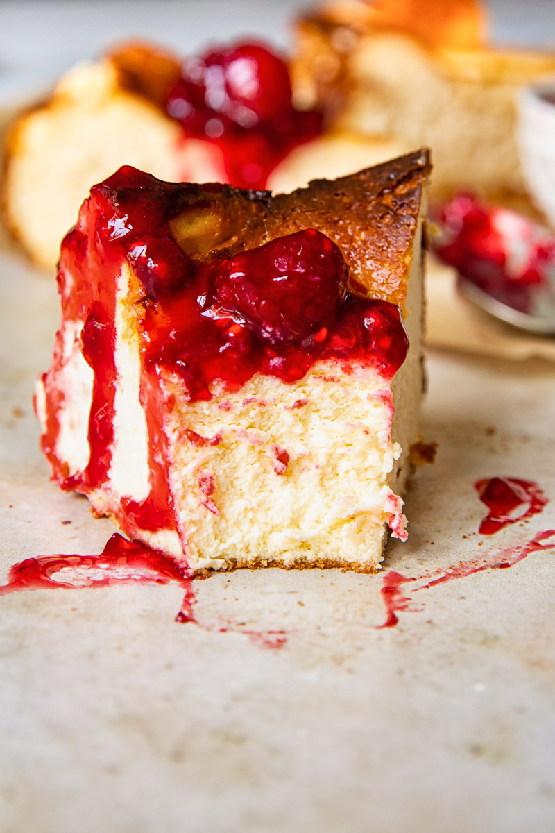 a slice of cheesecake topped with raspberries