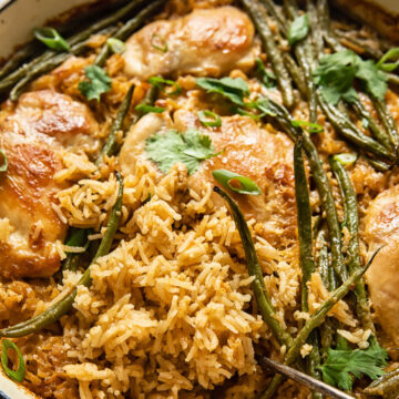 chicken and rice with green beans in white pan