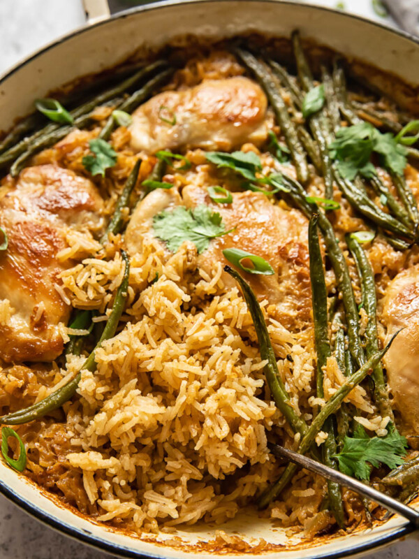 chicken and rice with green beans in white pan
