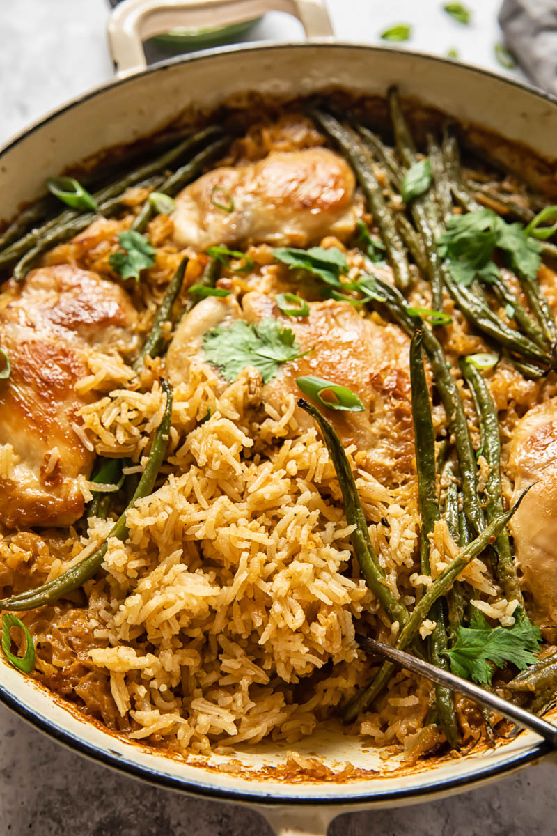 chicken and rice with green beans in white pan