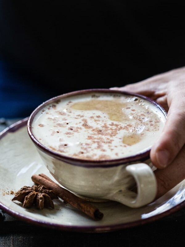a cup of coffee and hand holding it