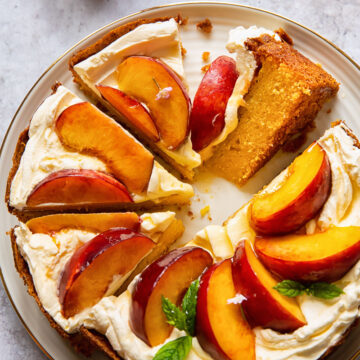 top down view of cake topped with whipped cream and sliced peaches