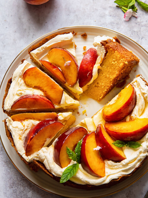 top down view of cake topped with whipped cream and sliced peaches