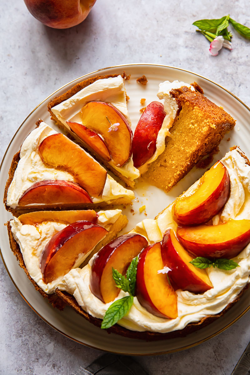 top down view of cake topped with whipped cream and sliced peaches
