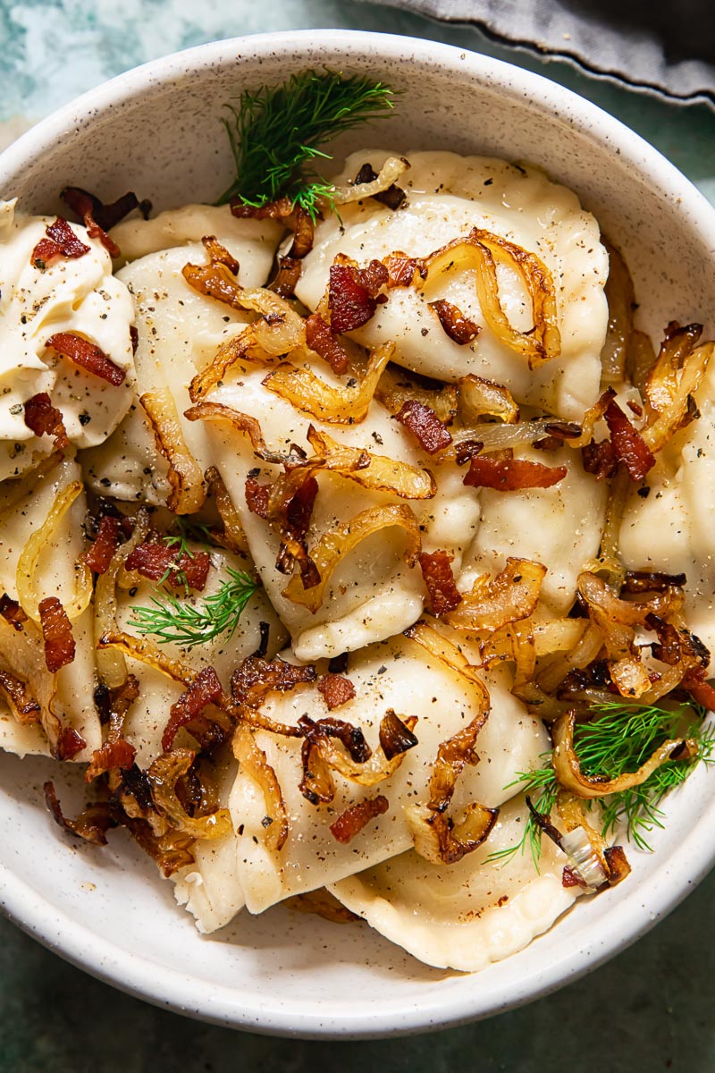 dumplings topped with fried onions and bacon in a bowl