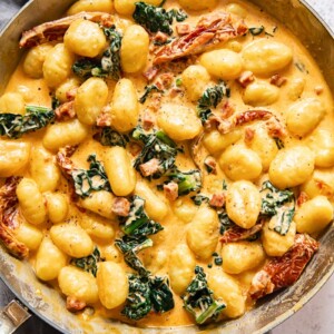 top down view of creamy gnocchi with sun-dried tomatoes and kale in a pan