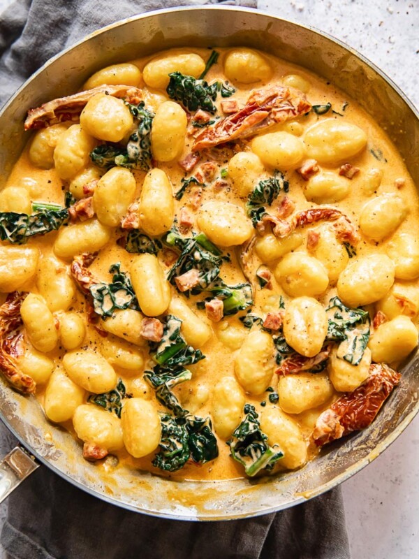 top down view of creamy gnocchi with sun-dried tomatoes and kale in a pan