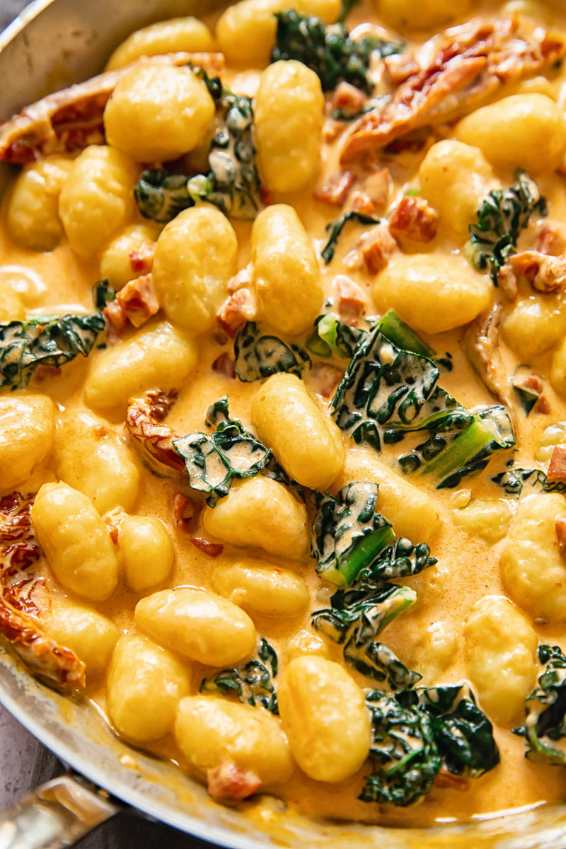 close up of creamy gnocchi pasta cooked with chorizo, kale and sun-dried tomatoes