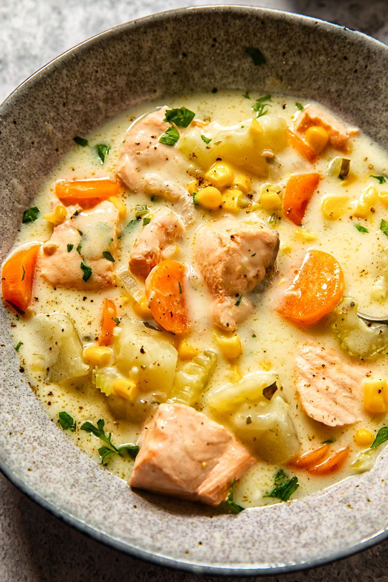salmon chowder in a grey bowl close up