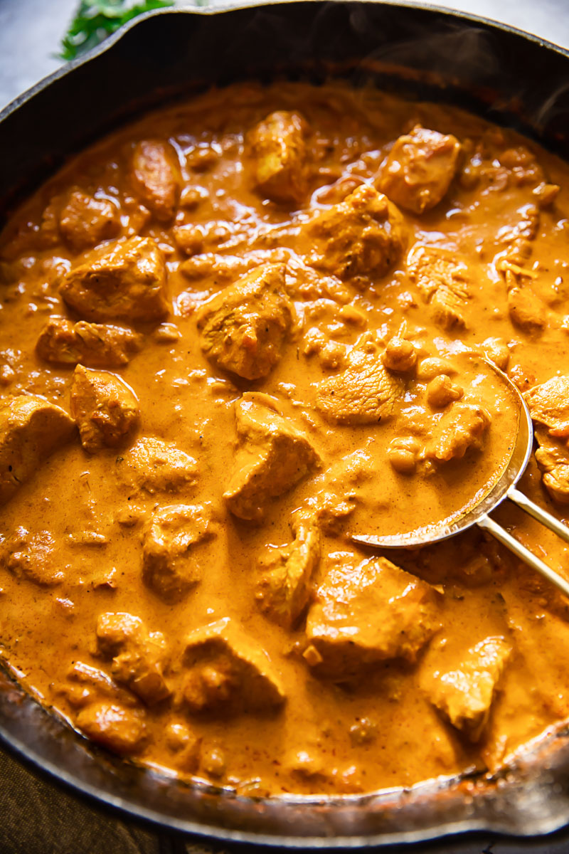 chicken curry with chickpeas in a black pan