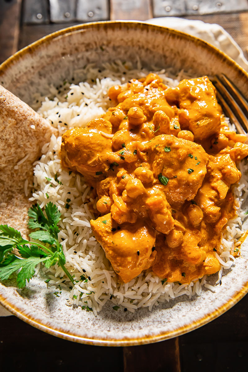 chicken tikka masala on top of basmati rice in a bowl