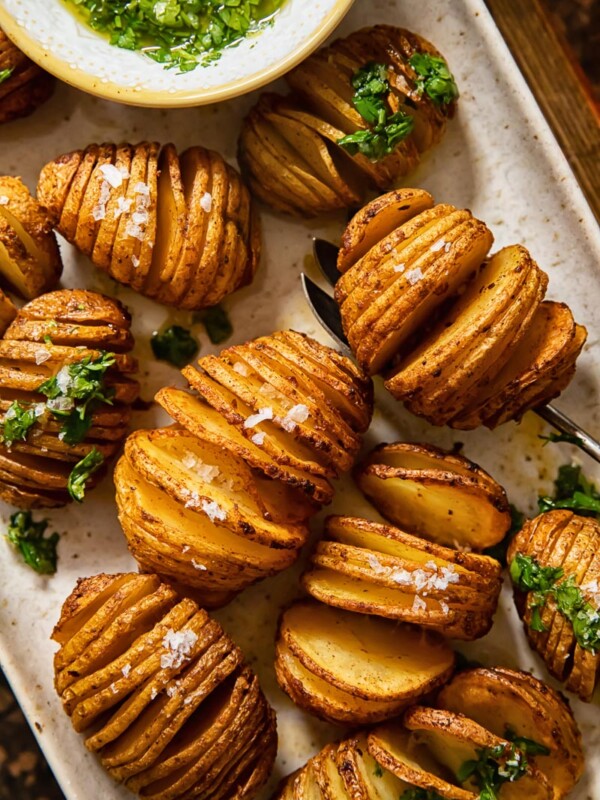 close up of potatoes on a platter sprinkles with sea salt and topped with gremolata