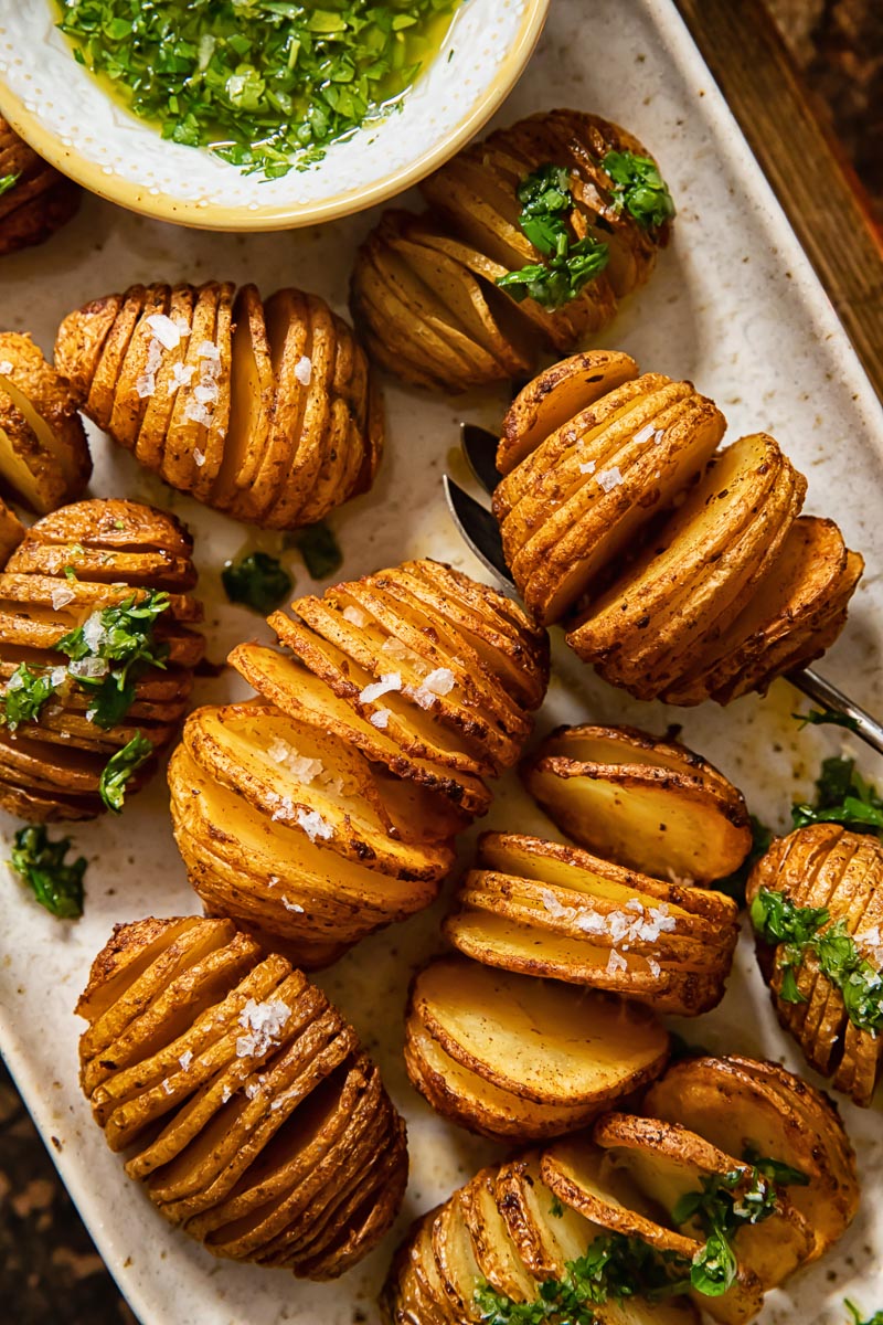 close up of potatoes on a platter sprinkles with sea salt and topped with gremolata