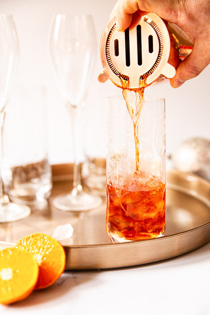 Negroni pouring from shaker into a glass