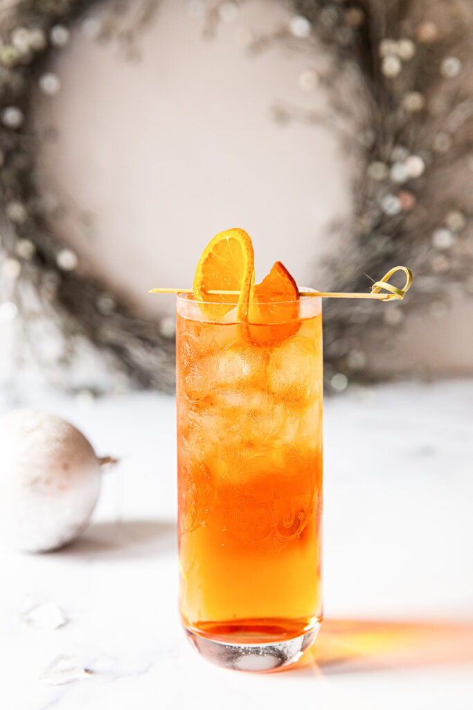 Negroni fizz on a table with wreath in the background