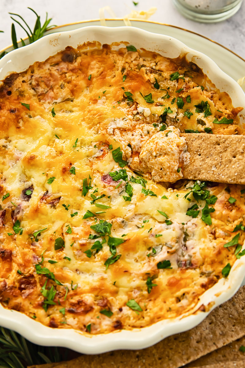 hot dip in a round serving dish with a cracker