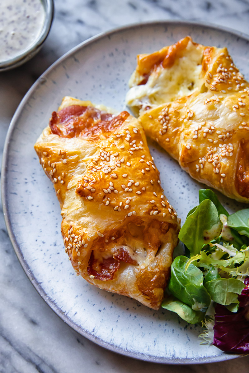 bacon and cheese turnovers on a plate, salad greens