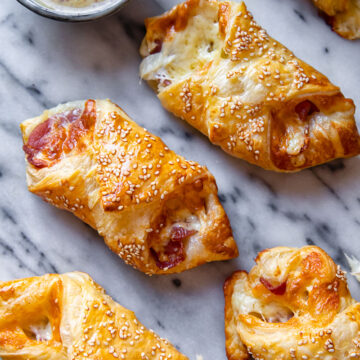 bacon and cheese turnovers on marble background with honey mustard sauce