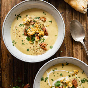 top down view of two bowls with soup in wooden background