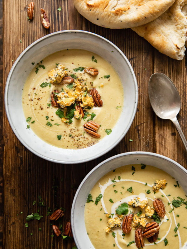 top down view of two bowls with soup in wooden background