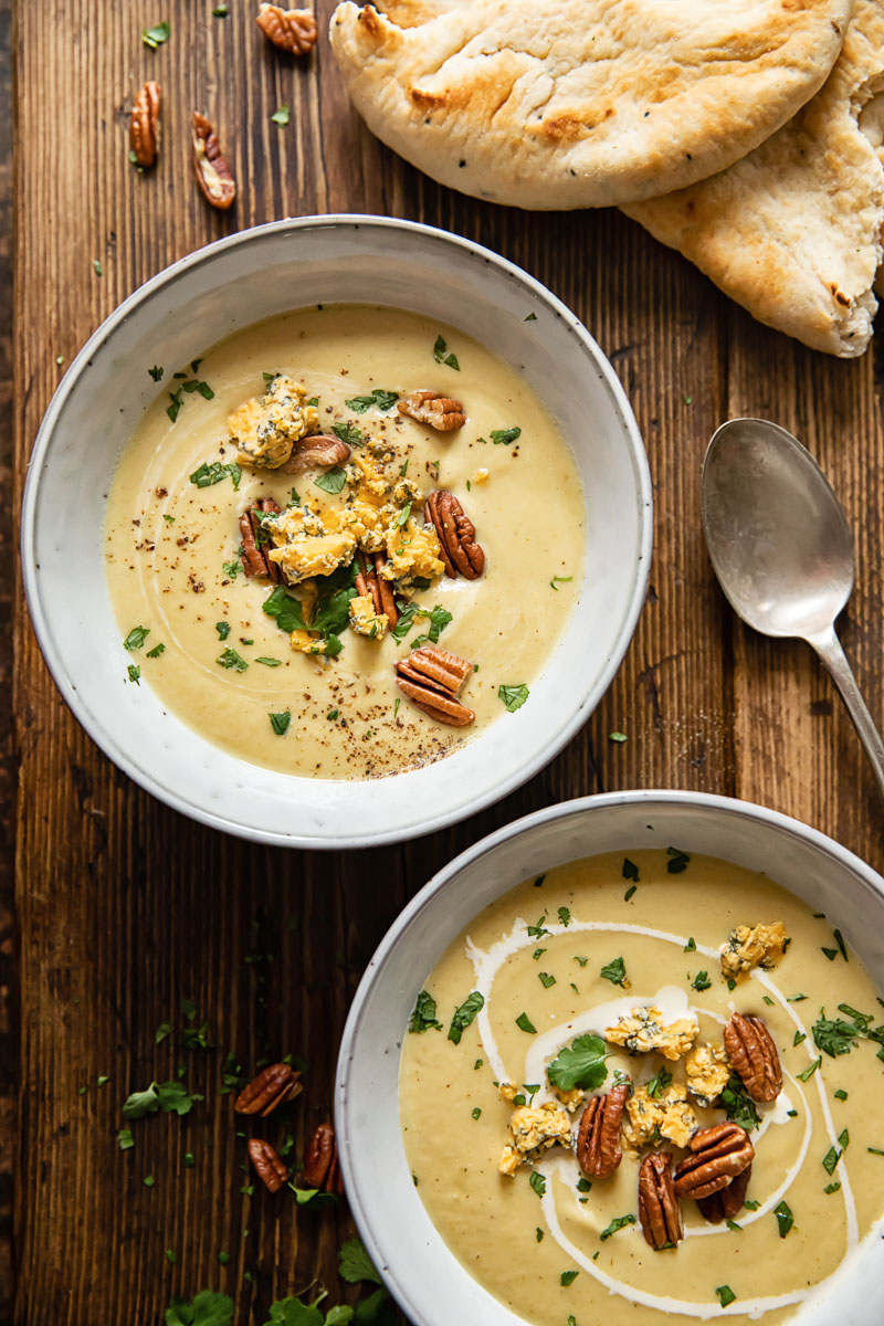 top down view of two bowls with soup in wooden background