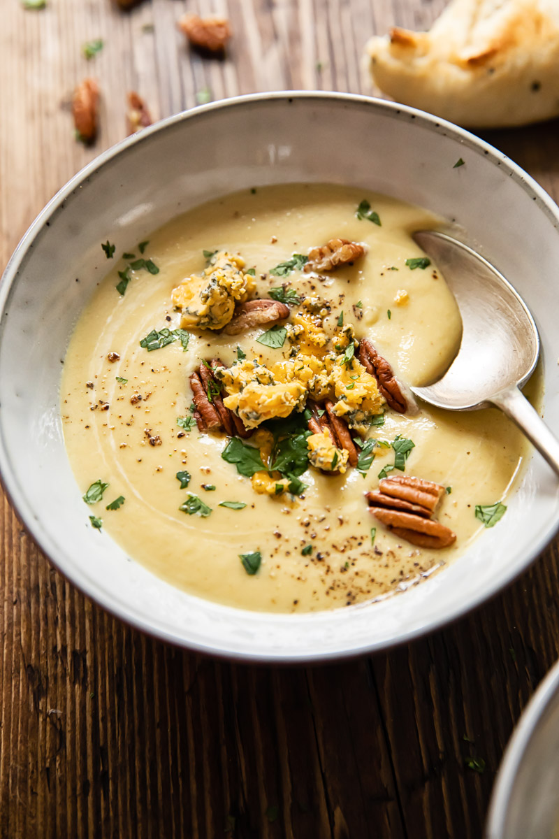 cauliflower soup topped with pecans and crumbled Stilton in a bowl
