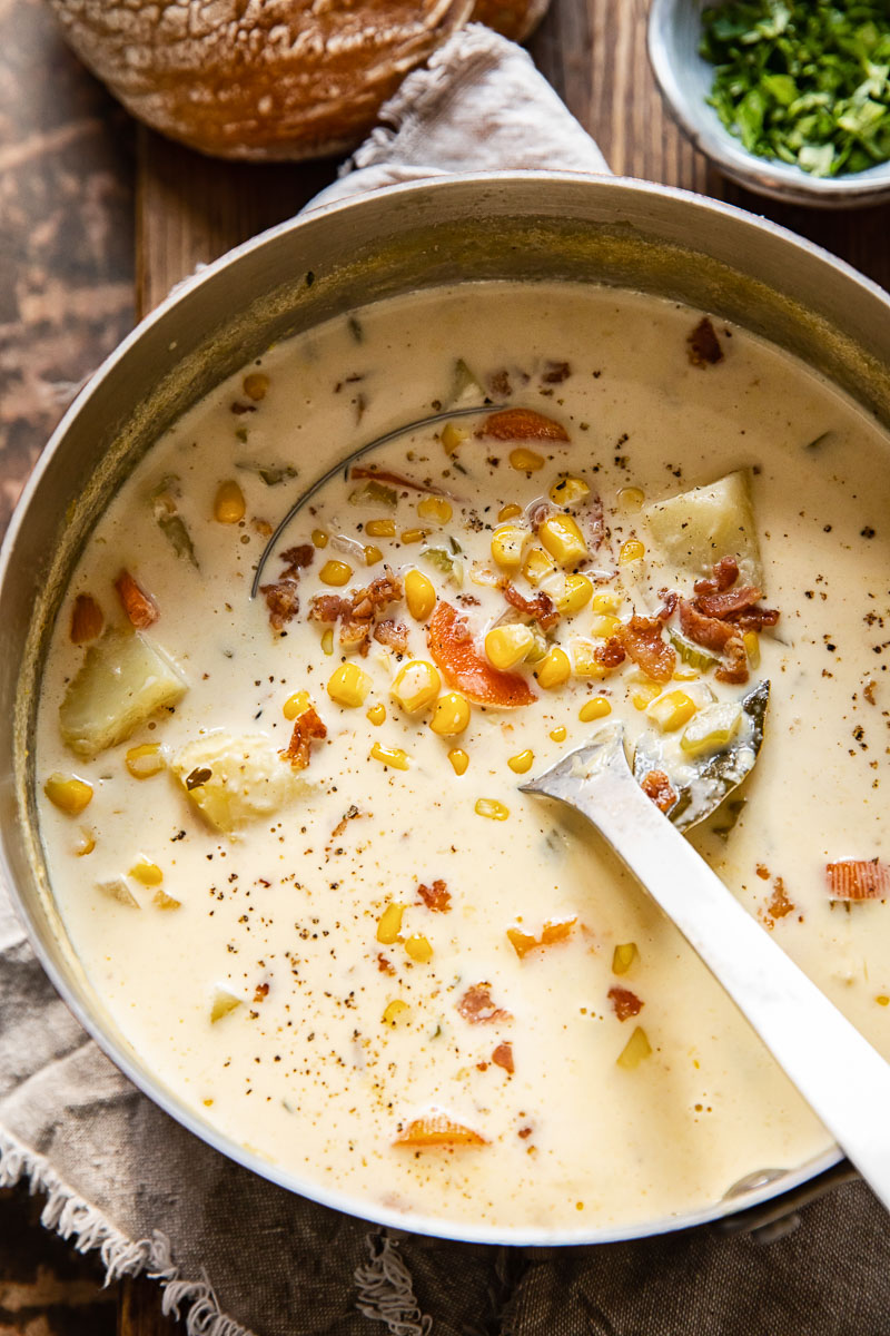 top down view of corn chowder in a pot with a ladle in