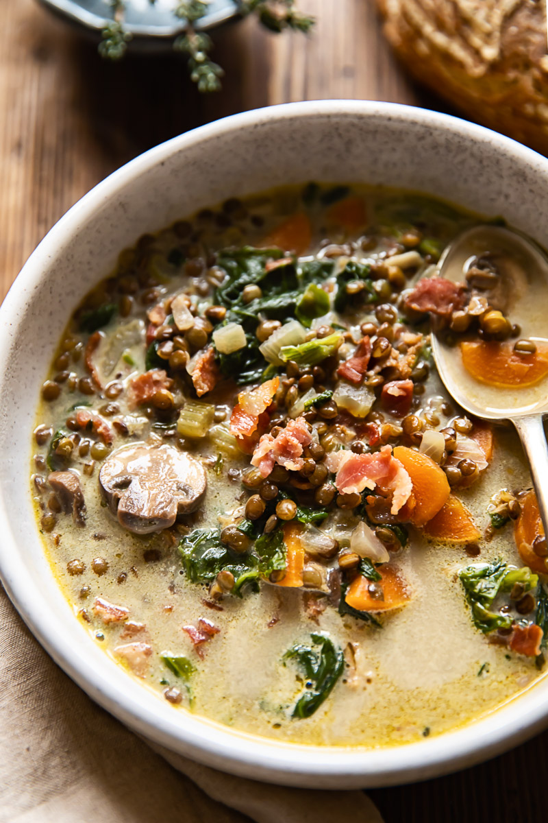 vegetable bacon and lentil soup in a beige bowl