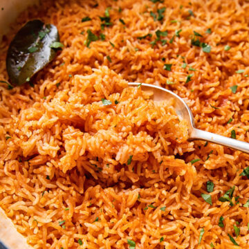 peri peri rice in a pan, scooped with a spoon