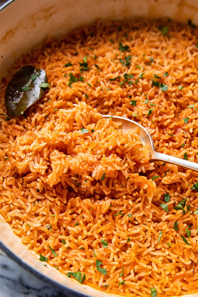 peri peri rice in a pan, scooped with a spoon