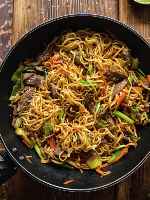 top down view of Asian noodles dish with beef and vegetables in a wok