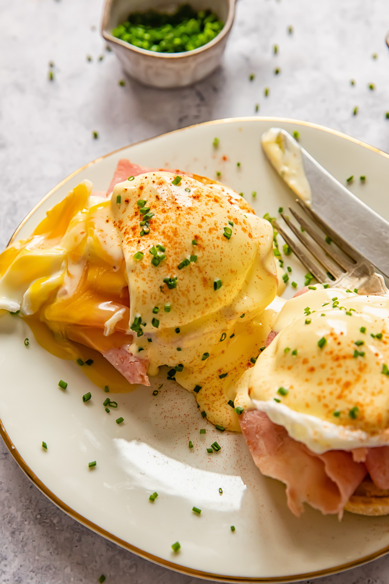 egg benedict on a plate with a yolk running out