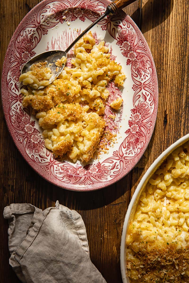 top down view of pasta on a platter and in a casserole dish, a cream napkin