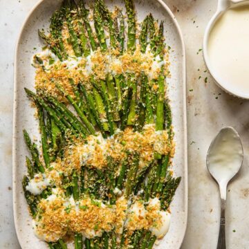 top down view of roasted asparagus with cheese sauce and breadcrumbs