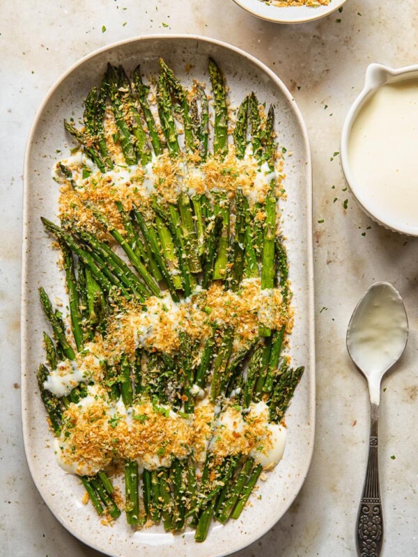 top down view of roasted asparagus with cheese sauce and breadcrumbs
