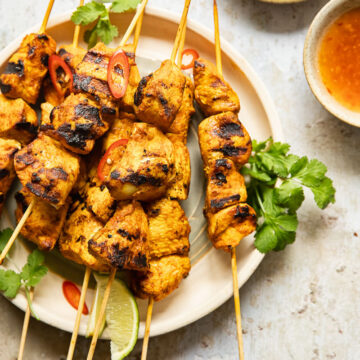 top down view of chicken satay with peanut sauce and red chilli sauce